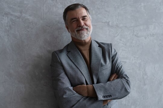 Entrepreneur in jacket smiling, Happy mid adult, mature age man standing, smiling, isolated on grey background