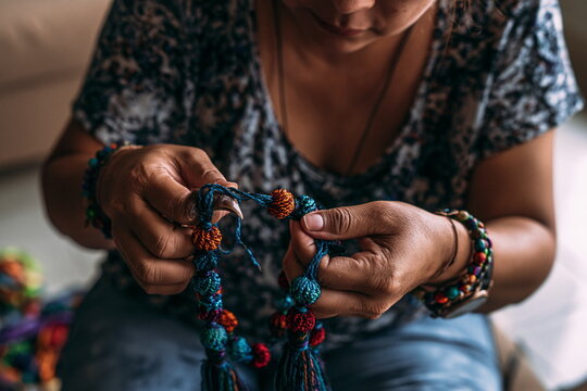 Dedicated Beadwork Artist Crafting Unique Handmade Jewelry with Teal and Coral Beads, Channeling Passion and Creativity in Every Intricate Design