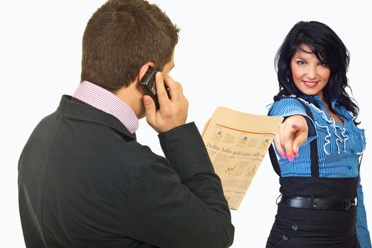 Man on phone, woman points accusingly