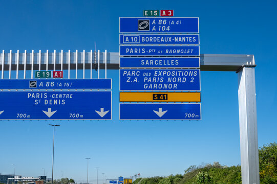 View of a French and European autoroute with overhead directional signs pointing to major cities like Paris, Bordeaux, Lille, Calais, showing lanes, traffic and motorway infrastructure, road signes