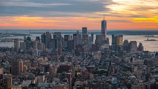 Manhattan Skyline Timelapse Transitioning from Golden Hour to Nighttime Cityscape Featuring Illuminated Skyscrapers and Urban Infrastructure Under a Dynamic Cloudscape