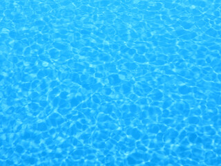 Obraz premium Sparkling blue pool water with light reflections. Background for summer themes.