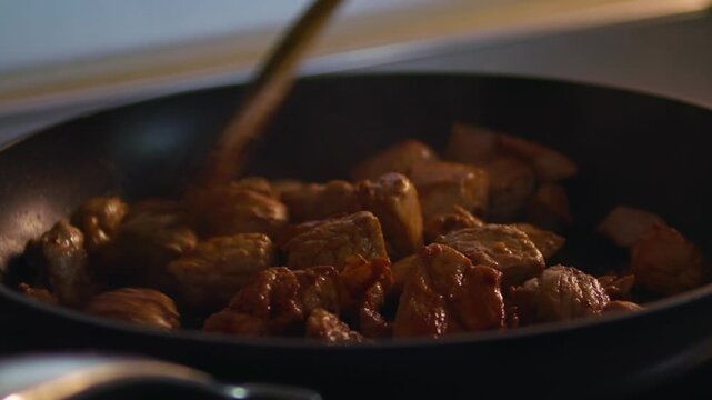 In einer hei&szlig;en Pfanne wird Schweinegulasch angebraten.