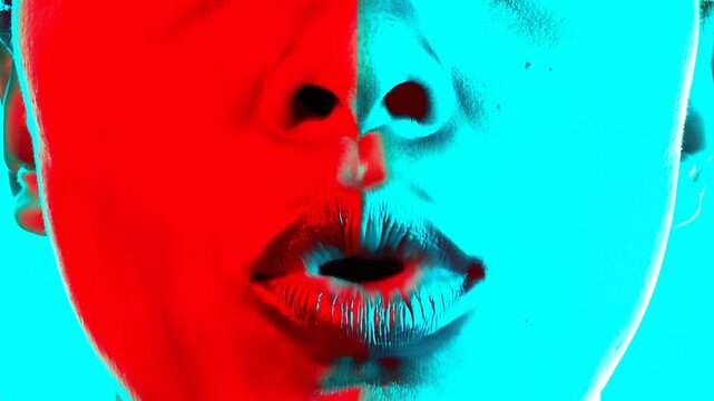 Static close up shot of lips opening and closing with split red and cyan lighting on face in studio portrait set, subtle mouth movement and synchronized lip motion