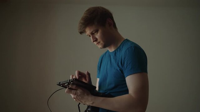 Professional filmmaker concentrating on setting up and calibrating external monitor, checking settings and parameters on touchscreen display before video shoot. Shooting in slow motion