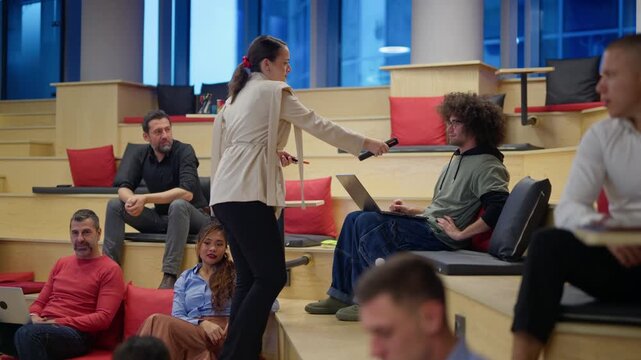 A female professional gives a microphone to a participant during an interactive business meeting in a modern office