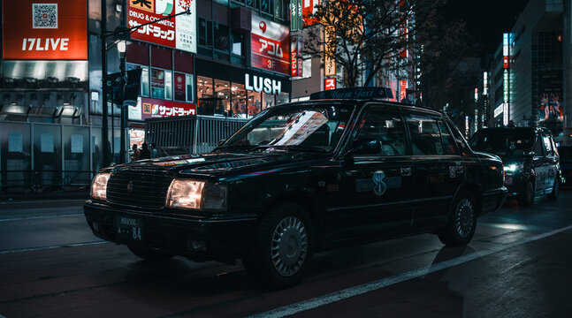 Tokyo, Japan: vintage taxi car in Shibuya intersection with neons