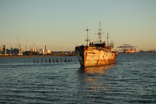 Front view of rusting ship in harbor waters
