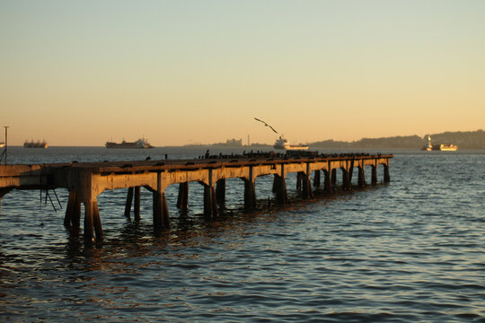 Old wooden pier extending into calm water at sunset