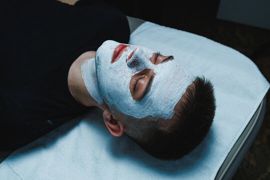Cosmetology appointment for a man receiving facial treatment at a beauty salon in the afternoon with products applied to nourish and refresh skin