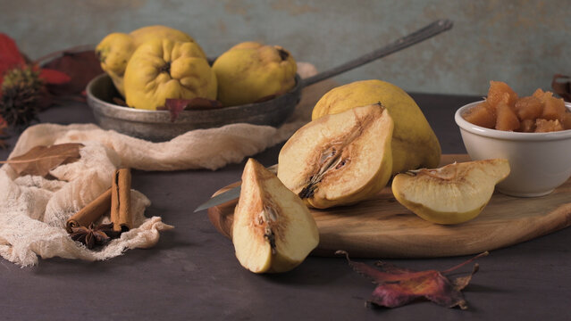 Still Life with Fresh Quinces Cinnamon Sticks and Compote on a Rustic Table