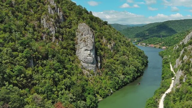 Aerial view of stone carved statue portrait of ancient dacian king Decebal. Sculpture located on shore of Danube River, Romania, 4k