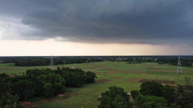 Dark Monsoon Storm Clouds Hovering Over Green Rural Landscape and Agriculture Fields.