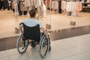 Obraz premium A Caucasian woman in a wheelchair shopping at a mall. 