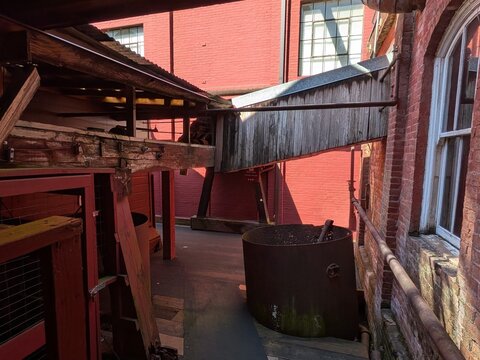 Historic covered flume and mill structures illustrate how water was directed through wooden channels to power textile production, preserving a remarkable chapter of industrial heritage.