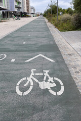 Obraz premium Dedicated bicycle lane in an urban environment with painted bike symbol and directional arrow on the pavement. Sustainable city transport infrastructure promoting cycling, eco-friendly commuting