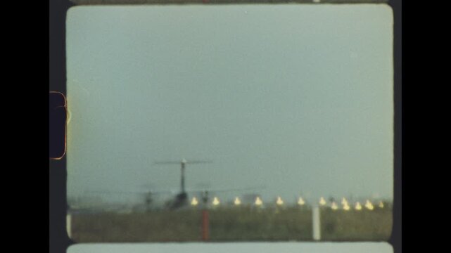 A commercial aircraft on a distant runway lined with glowing approach lights in misty dusk haze, filmed on retro super 8 film