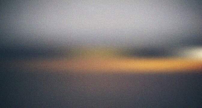 Dark atmospheric abstract blur with a bright horizontal orange glow creating a sense of dramatic illumination