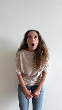 Mujer blanca muy sorprendida abriendo ojos y boca