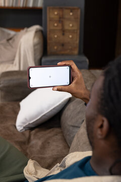 Smartphone is displaying alignment markers while resting on brown sofa with white pillow at home