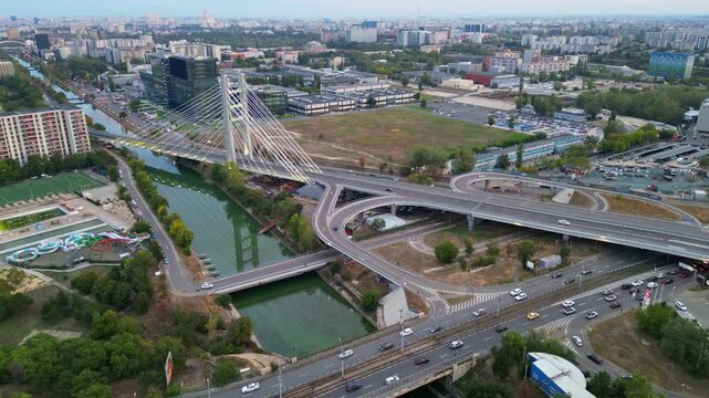 High angle twilight view of the modern Ciurel cable-stayed bridge in Bucharest, Romania. Scenic urban infrastructure with glowing traffic lights at sunset.