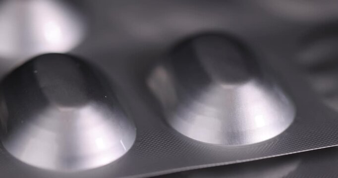 A metal blister with cells, this protective blister has a raised granular texture and oval cavities for pharmaceutical products.