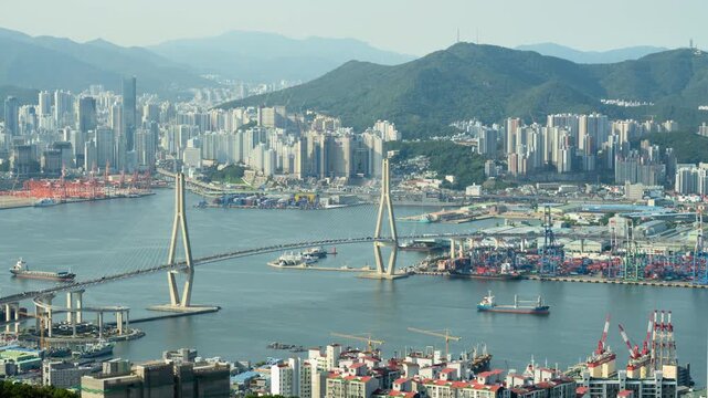 Timelapse of Busan Harbor Bridge and busy Busan port with ship and cars traffic, wide angle view from Bongrae Mountain. Busan Metropolitan City is the second most populous city in South Korea