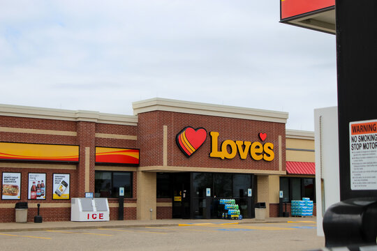 A Love's Travel Stop with its signature red heart logo prominently displayed on a brick facade in Menomonie, Wisconsin on May 17, 2026. Editorial Use Only.
