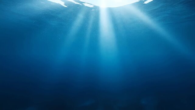 Sunlight rays penetrating deep blue ocean water, underwater background
