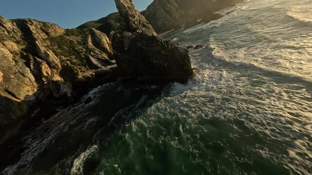 FPV drone at Praia da Ursa in Portugal at sunset with coastal cliffs and Atlantic Ocean.
4K high quality cinematic aerial footage.