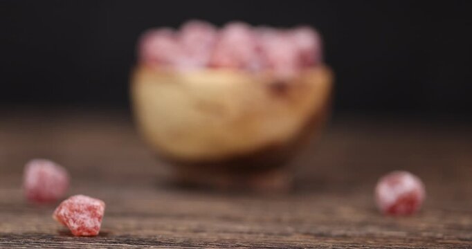 small orange fruits of fragrant kumquat dried in sugar syrup, food details, round dehydrated kumquat fruit in a wooden bowl