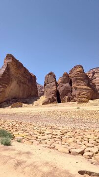 View from a moving vehicle's window showing the rocky mountains in a wild open space at Alula Saudi Arabia on a sunny day
