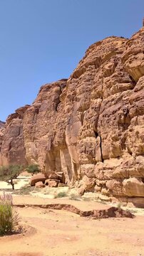 View from a moving vehicle's window showing the rocky mountains in a wild open space at Alula Saudi Arabia on a sunny day