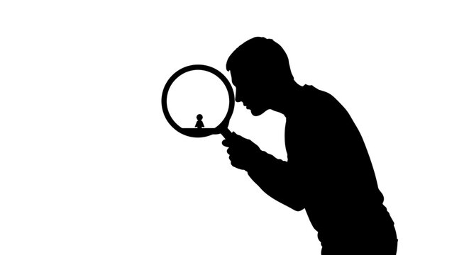 Man looking through magnifying glass closely.