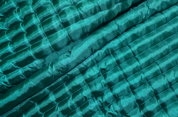 Obraz premium surface of the floor mattress is green with soft, textured, wavy, and shiny fabric.