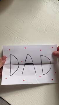 Vertical top-down video: opening a card with &ldquo;DAD&rdquo; on the cover, revealing &ldquo;Happy Father&rsquo;s Day&rdquo; inside.
