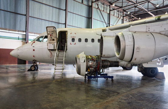 Turboprop aircraft engine on maintenance stand maintenance inspection inside airport hangar.