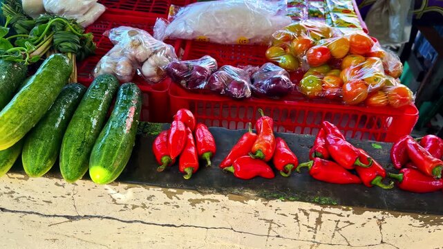 Colorful assortment of red chili peppers and other fresh produce displayed at an outdoor market stall in Surigao, Philippines.