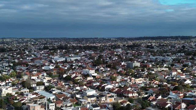 drone video of a city during the day, stadium and playground,
dramatic sky and sea horizon, aerial shot of a village by the ocean,