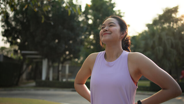 Asia young Gen Z people mindful happy woman open arm relax body deep stress relief outdoor nature green public park sun light self love anti aging life asian female mental health care modern medical.