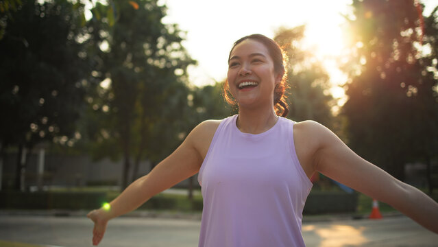 Asia young Gen Z people mindful happy woman open arm relax body deep stress relief outdoor nature green public park sun light self love anti aging life asian female mental health care modern medical.