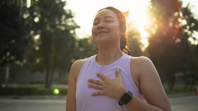 Asia young Gen Z people mindful happy woman open arm relax body deep stress relief outdoor nature green public park sun light self love anti aging life asian female mental health care modern medical.