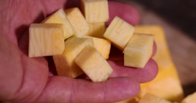 orange pumpkin cut into pieces on a wooden chopping board, preparing sweet pumpkin for baking in the kitchen