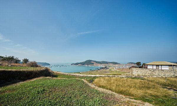 A serene series captures the idyllic beauty of Cheongsando Island, South Korea. Images of rustic dirt paths, stone walls, terraced fields, and a coastal village illustrate slow living and eco-tourism.