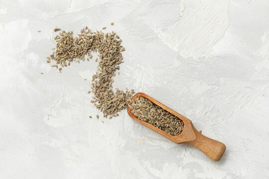 Wooden scoop with dried anise seeds on grunge background