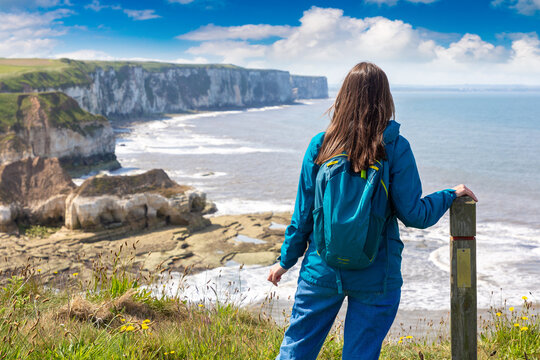 Female hiker at white chalk cliffs of yorkshire coastline in Flamborough, England, UK