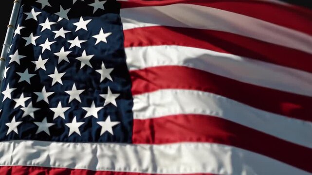 Close-up view of the American flag waving in the wind, showcasing its stars and stripes.