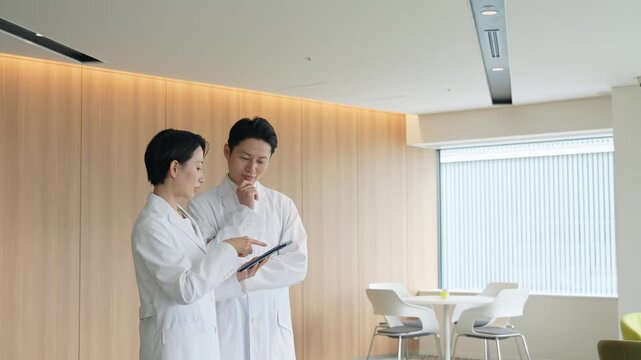 画面を見ながら会話する白衣の男女グループ