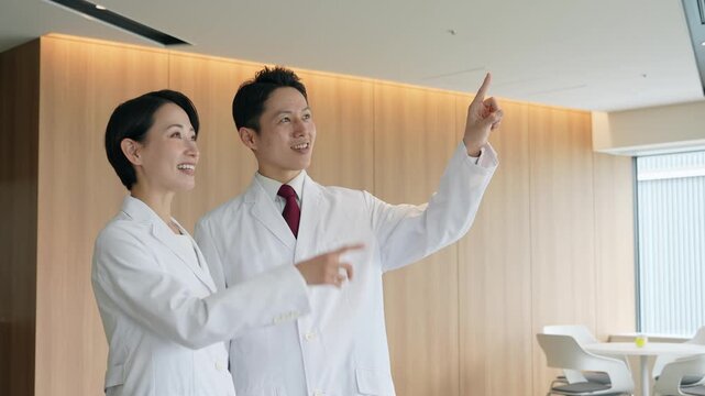 画面を見ながら会話する白衣の男女グループ