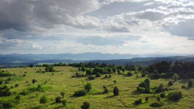 Aerial 4K drone video of Slovak Paradise national park landscape with green meadows and rolling hills under a dramatic sky. Scenic Slovensky Raj nature, wilderness, and travel concept